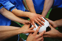 Picture of everyones hands on the soccer ball
